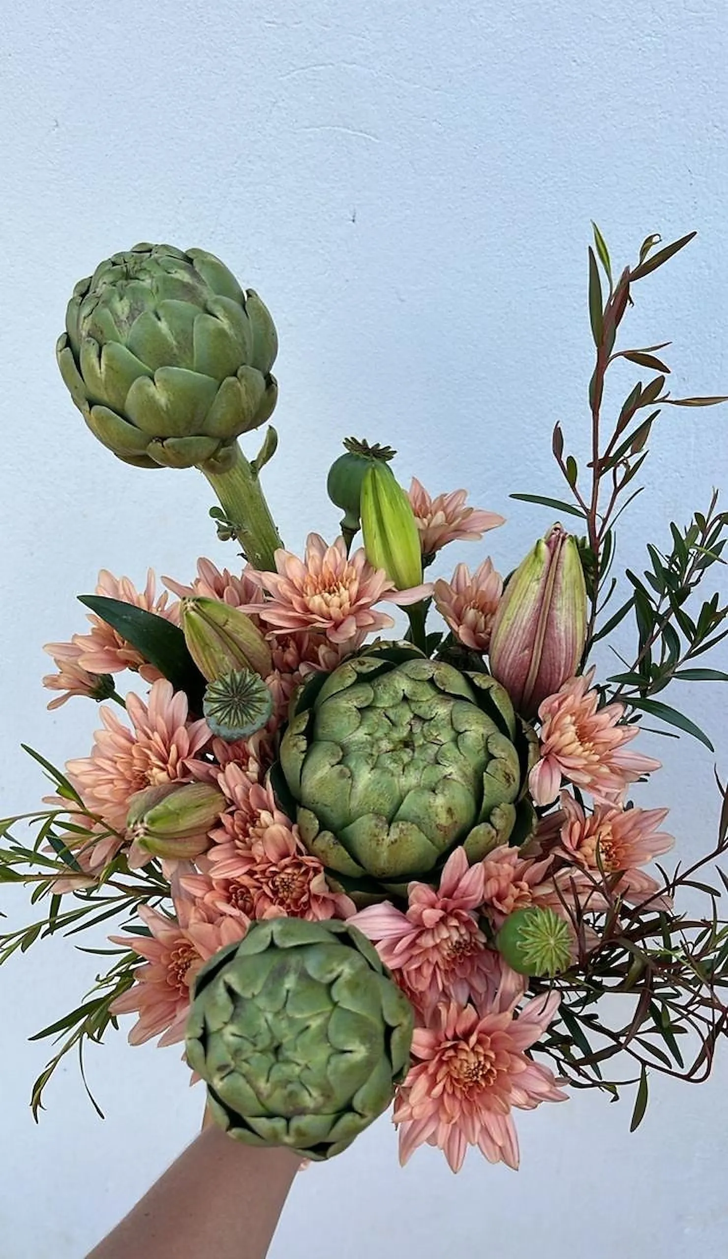 A bouquet of globe artichokes and dusty pink chrysanthemums